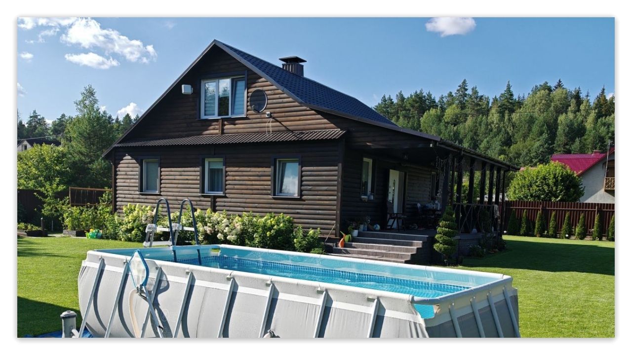 There is a medium-sized above-ground swimming pool on the front lawn of the house.