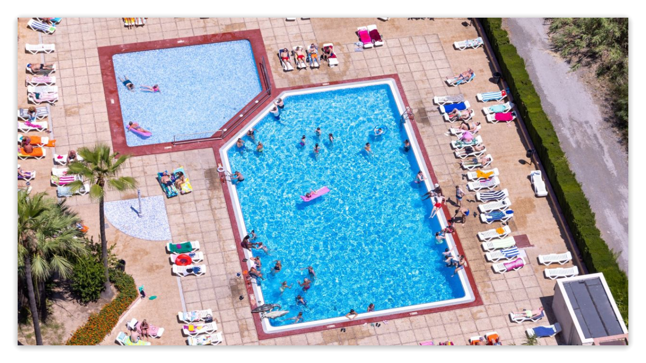 Aerial view of hotel pools with people swimming and lounging around