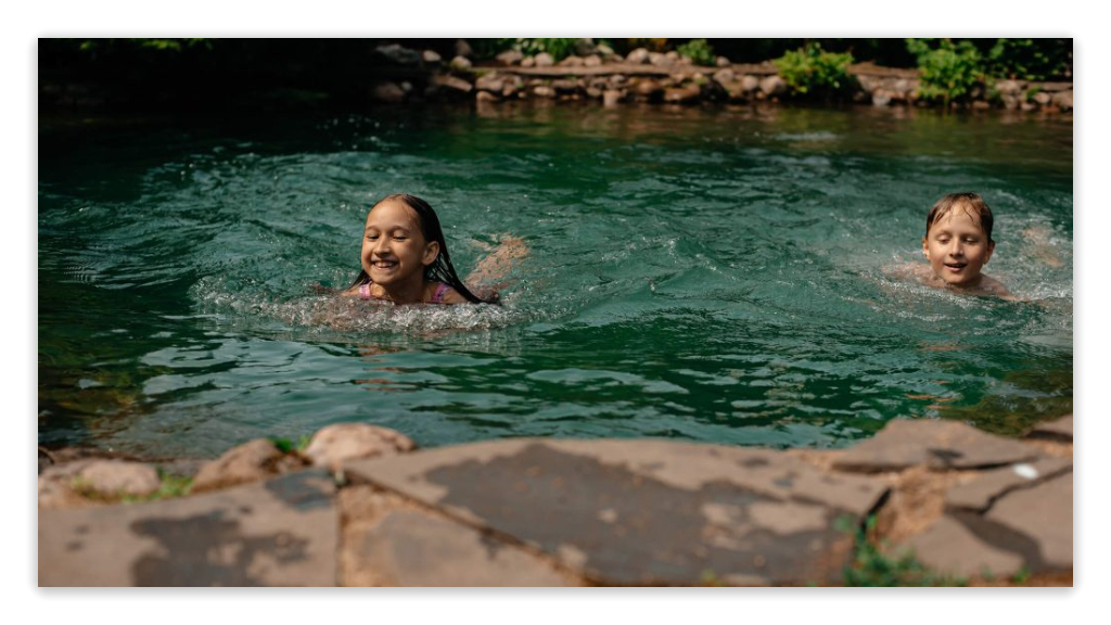 children swimming in a natural pool