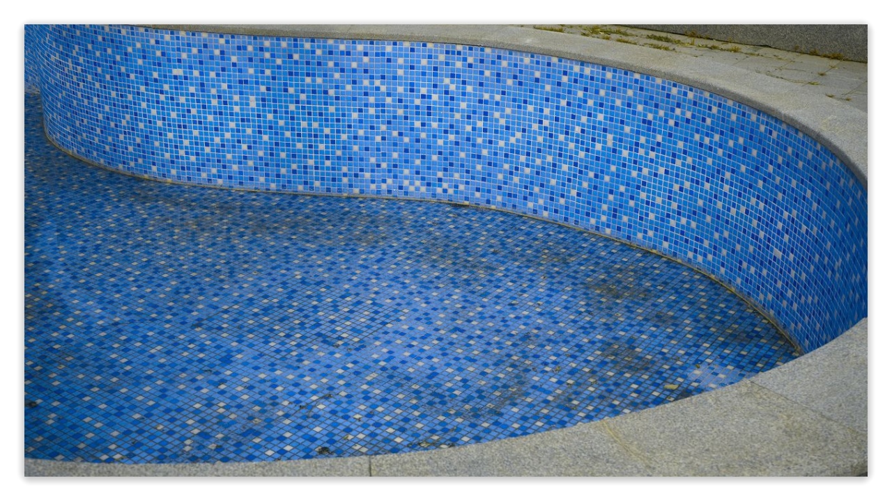 Curved pool wall with blue mosaic tiles