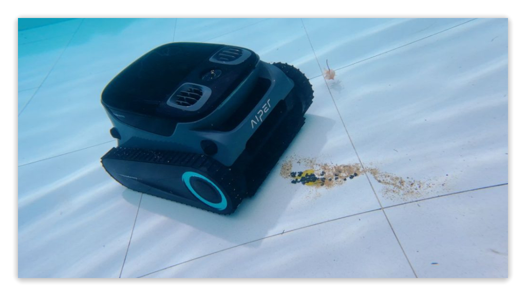 pool cleaning robot scrubbing the bottom of a pool to remove dirt and debris.
