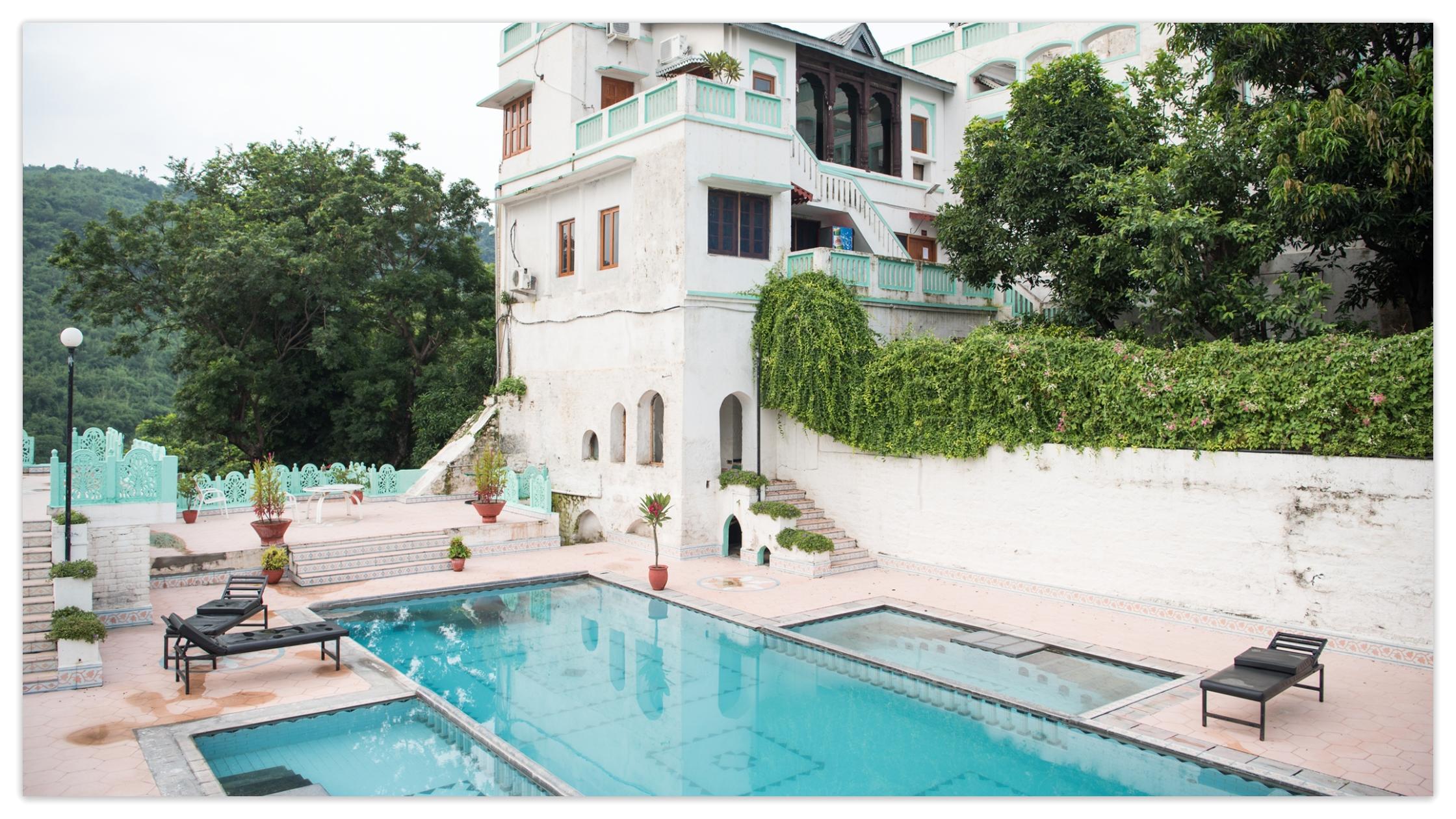A pool is surrounded with lush green plants.