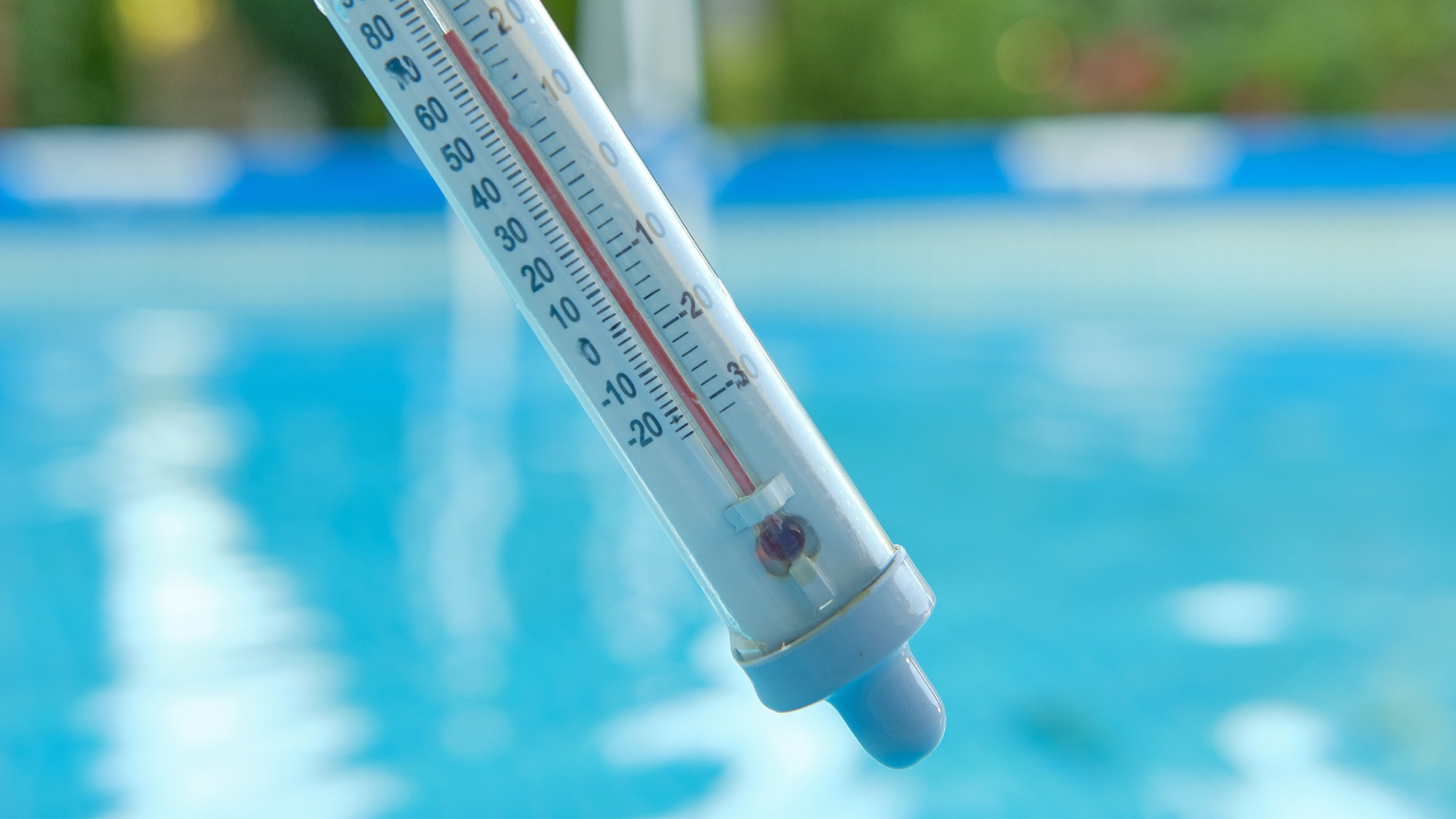 Close-up of a pool thermometer showing ideal pool temperature