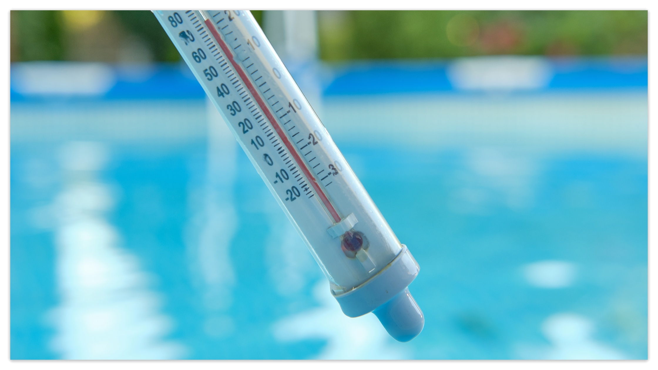 Close-up of a pool thermometer displaying the water temperature, crucial for maintaining the best pool water temperature.
