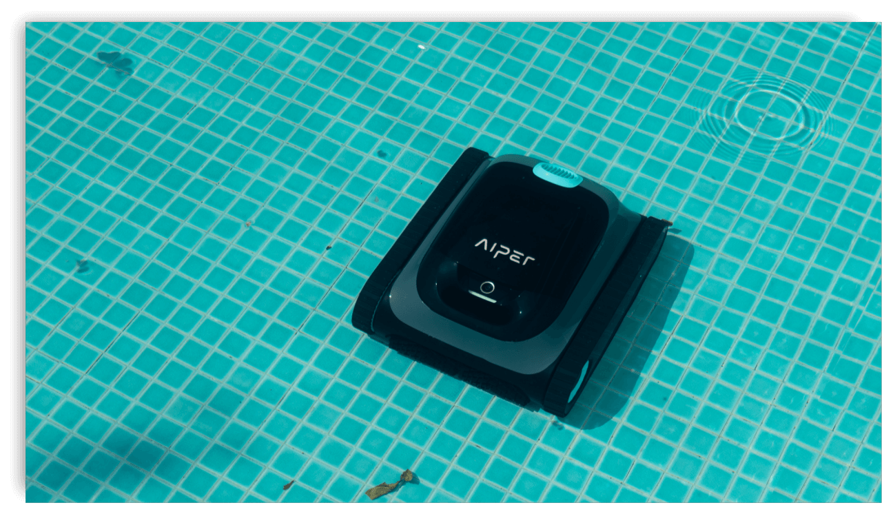 A robotic pool cleaner in action on the bottom of a clean pool, preparing for pool opening.