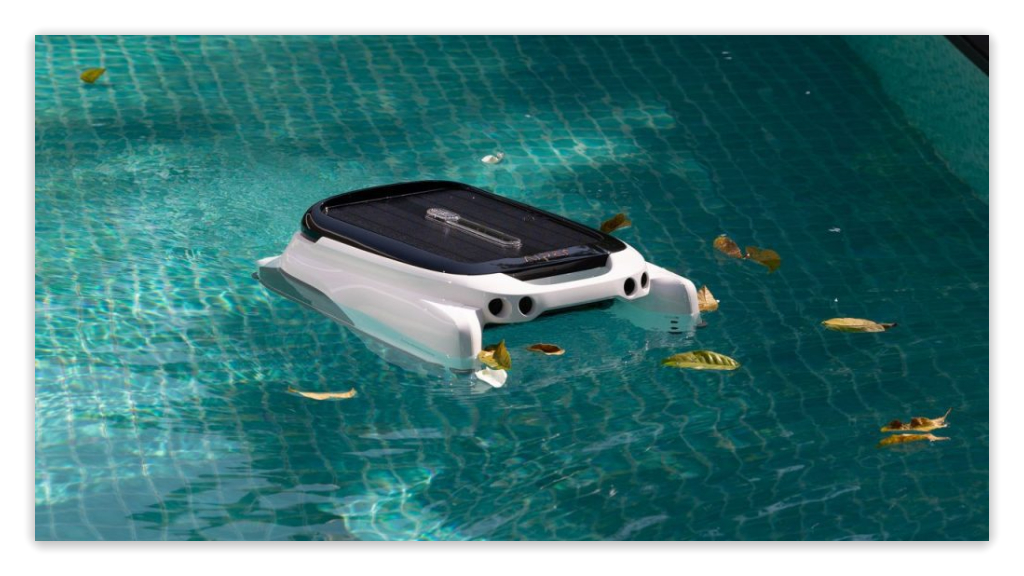 A robotic pool cleaner is skimming to remove leaves and debris on the surface.
