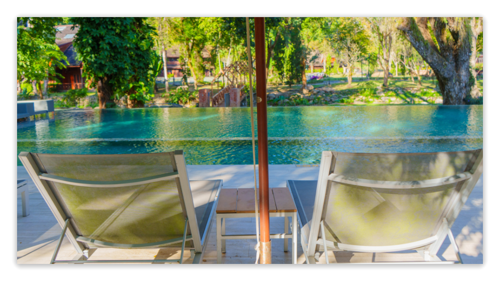 Serene hotel salt water pool with lounge chairs and lush greenery