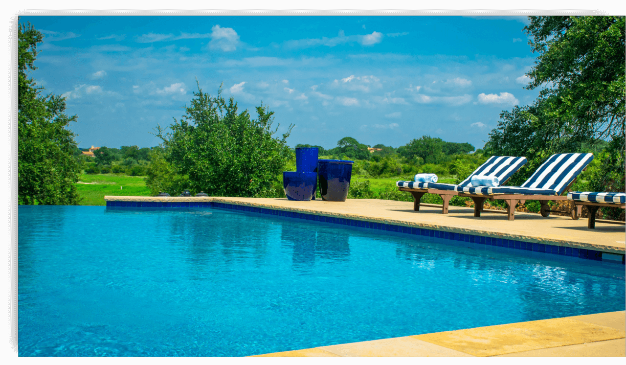 A sparkling swimming pool with lounge chairs and a scenic background, ready for summer opening.