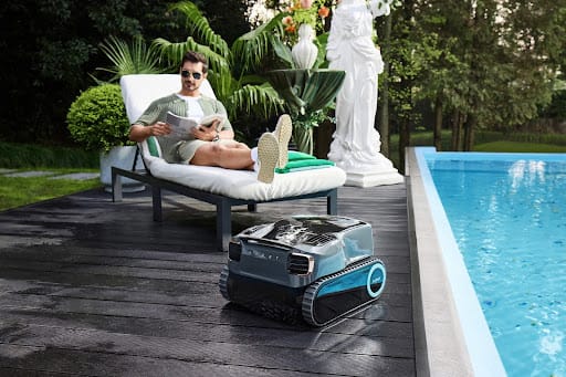 Man relaxing next to Aiper robot pool cleaner